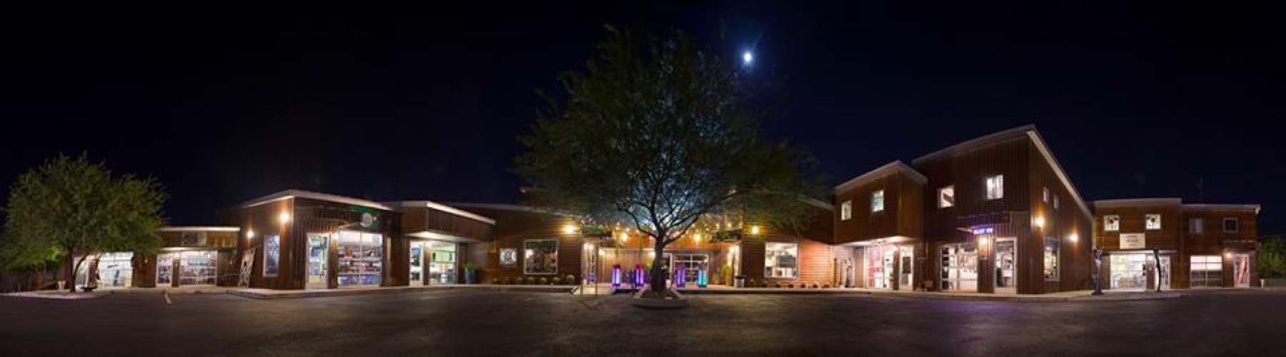 A wide night view of the Metal Arts Village courtyard under a full moon.